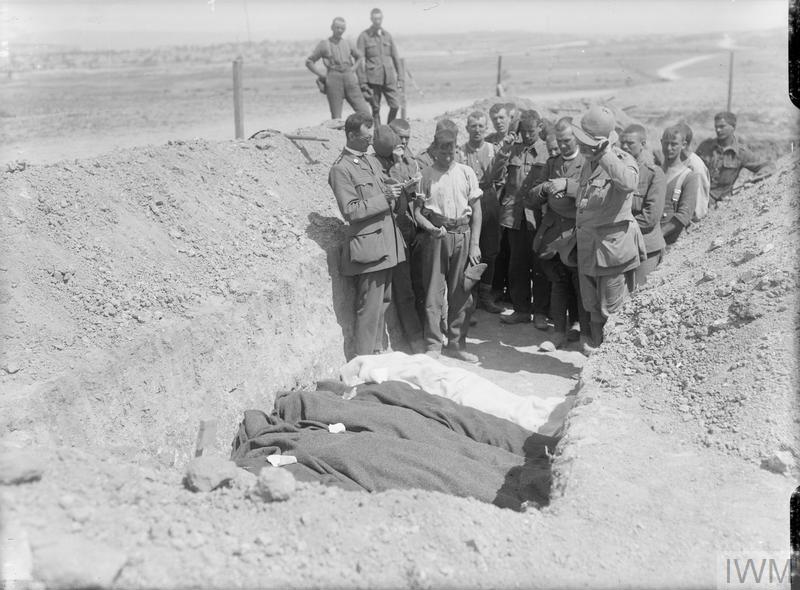 A military chaplain leads a funeral ceremony for four British soldiers in a trench at Gallipoli.