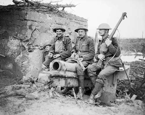 Men of the 4th Coldstream Guards perch on wrecked gun by a blockhouse on the outskirts Houlthulst Forest, 9 Oct 1917 © IWM Q 6046